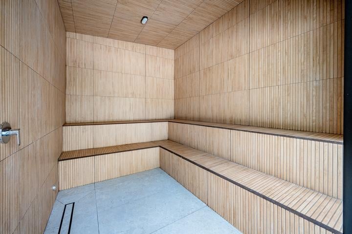 Beachfront Jaco, Costa Rica - Vacation Rental Casa Las Palmas • Costa Rica Elite Interior of a wooden sauna with three-tiered benches along three walls and a ceiling light.
